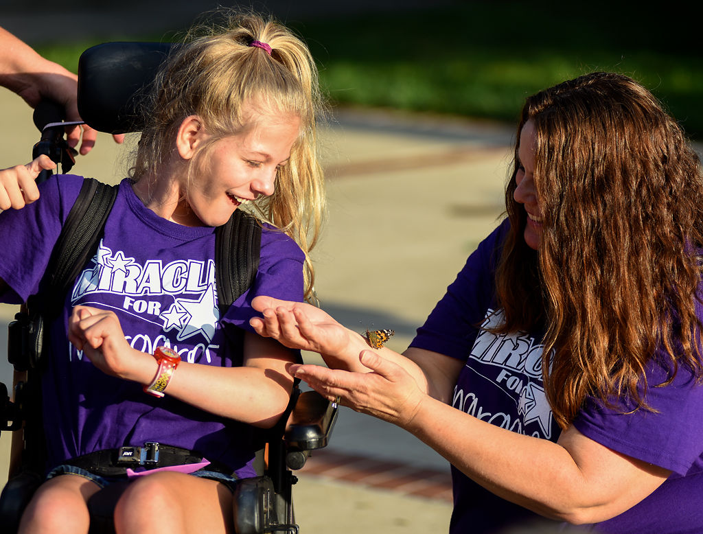 Cassidy-Rae Luebbering smiles at a butterfly